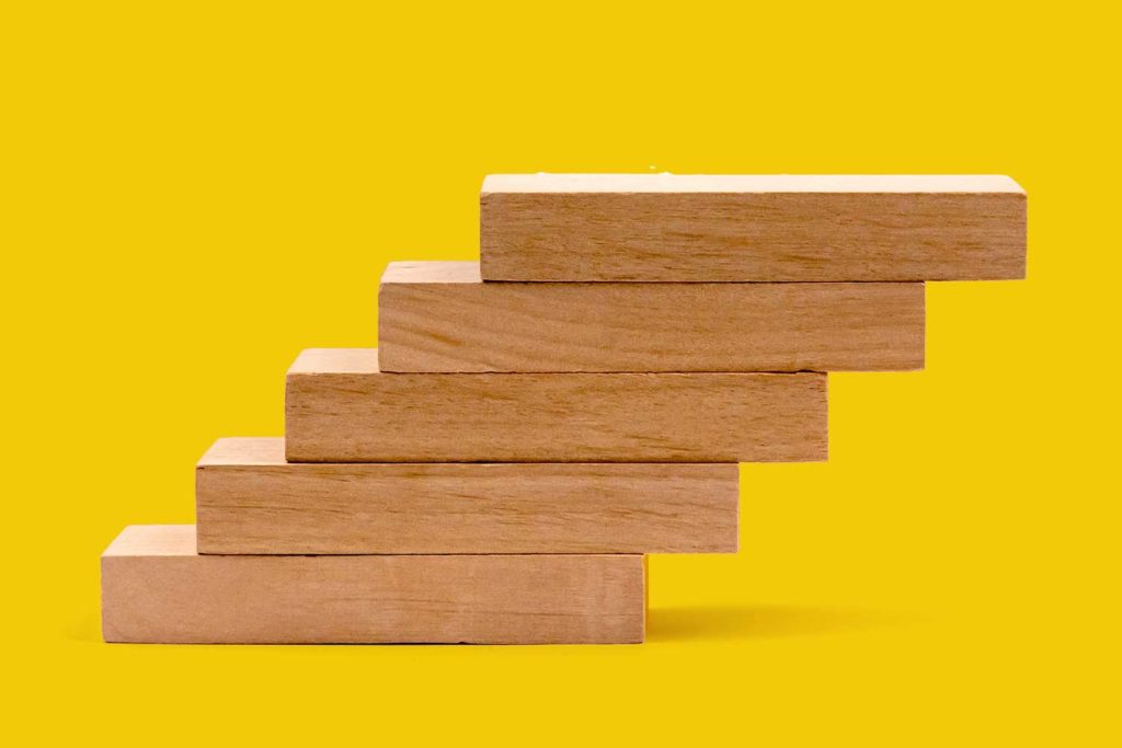 doubling content marketing - wooden blocks stacked on yellow background